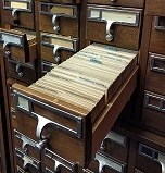 photo of drawers on a library card catalog with one drawer open